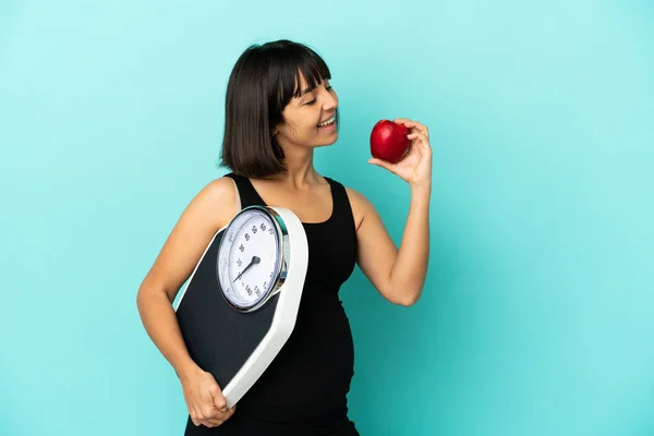 Schwangere Vor Isoliertem Hintergrund Mit Wiegemaschine Und Einem Apfel — Stockfoto
