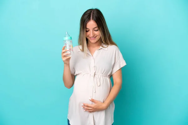 Jovem Romena Isolada Fundo Azul Grávida Segurando Uma Mamadeira — Fotografia de Stock