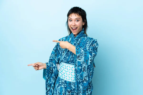 Mujer Joven Usando Kimono Sobre Fondo Azul Aislado Sorprendido Apuntando —  Fotos de Stock