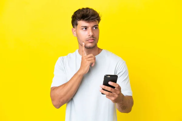 Hombre Guapo Caucásico Joven Aislado Sobre Fondo Amarillo Usando Teléfono —  Fotos de Stock