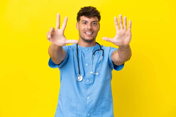 Молодий Хірург Лікар Чоловік Ізольований Жовтому Тлі Підраховуючи Вісім Пальцями — стокове фото