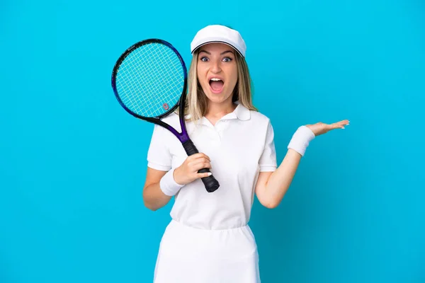若いテニスプレーヤールーマニアの女性はショックを受けた顔の表情で青の背景に隔離 — ストック写真