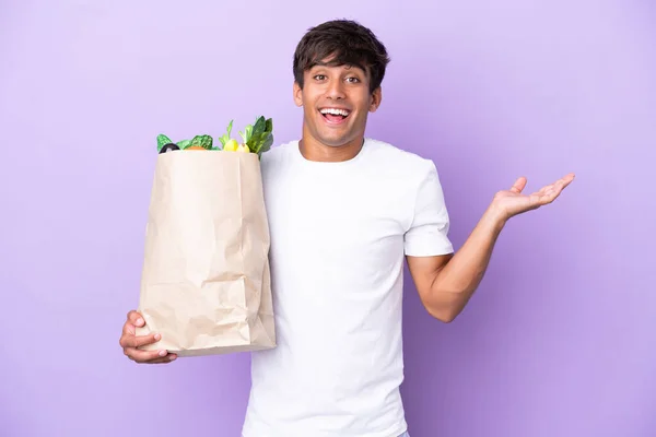 Ung Man Som Håller Matkasse Isolerad Lila Bakgrund Med Chockad — Stockfoto