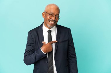 İşletme son sınıf öğrencisi, mavi arka planda sürpriz bir yüz ifadesiyle izole edilmiş.