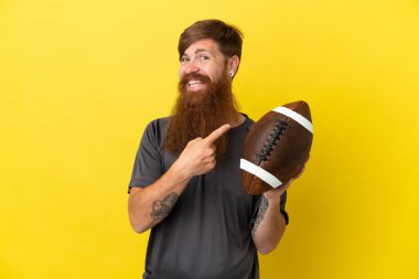 Kızıl saçlı beyaz adam sarı arka planda ragbi oynuyor.