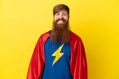 Kızıl saçlı süper kahraman, sarı arka planda izole edilmiş gülüyor.