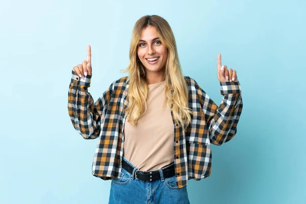 Jovem Loira Uruguaia Isolada Fundo Azul Apontando Para Uma Ótima — Fotografia de Stock