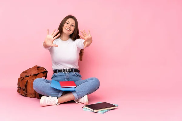 Adolescente Caucasiano Estudante Menina Sentado Chão Isolado Fundo Rosa Contando — Fotografia de Stock