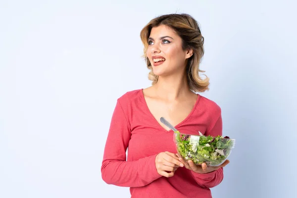 Mulher Adolescente Com Salada Isolada Fundo Azul Olhando Para Cima — Fotografia de Stock