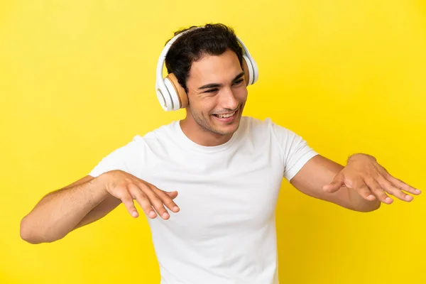 Caucasiano Bonito Homem Sobre Isolado Amarelo Fundo Ouvir Música Dança — Fotografia de Stock
