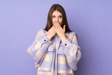 Mor arka planda izole edilmiş beyaz bir kız ağzı ellerle kapatıyor.