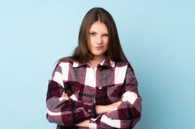 Kafkasyalı genç kız mutsuz bir ifadeyle mavi arka planda izole edildi