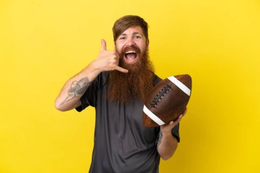 Kızıl saçlı beyaz adam sarı arka planda ragbi oynuyor.