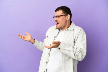 Brezilya 'lı bir adam mor arka planda, sürpriz bir ifadeyle yan tarafa bakıyor.