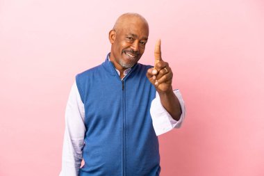 Kübalı son sınıf öğrencisi pembe arka planda izole edilmiş ve parmağını kaldırıyor.