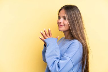 Sarı arka planda izole edilmiş genç beyaz kadın bir şeyler planlıyor.