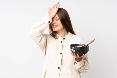 Beyaz arka planda izole genç beyaz kız bir şey fark etti ve bir kase erişteyi yemek çubuğuyla tutarken çözüme niyetlendi.