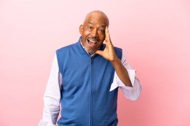 Kübalı son sınıf öğrencisi pembe arka planda ağzı açık bağırıyor.