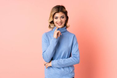 Genç Rus kadın pembe arka planda yalnız gülüyor.