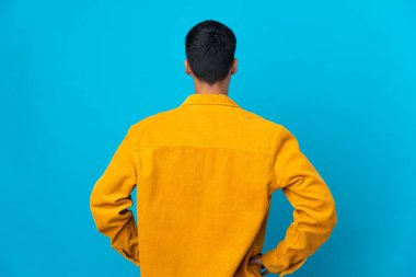 Arka planda izole edilmiş mavi arka planda genç bir adam var.