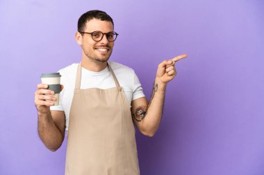 İzole edilmiş mor arkaplan üzerinde Brezilyalı restoran garsonu parmağı kenarda gösteriyor.