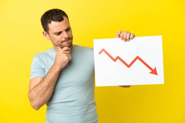 İzole edilmiş mor arkaplan üzerinde Brezilyalı bir adam elinde azalan istatistik okunun sembolü ve düşüncesi olan bir tabela tutuyor.