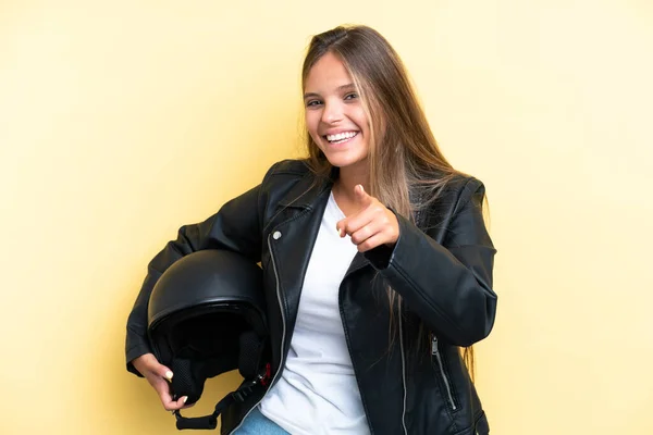 若いですCaucasian女性とともにオートバイヘルメット隔離上の黄色の背景ポインティングフロントで幸せな式 — ストック写真