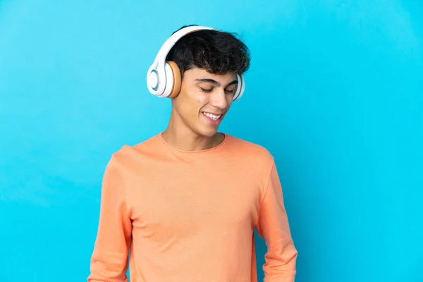 Νεαρός Πάνω Από Απομονωμένο Μπλε Φόντο Ακούγοντας Μουσική — Φωτογραφία Αρχείου