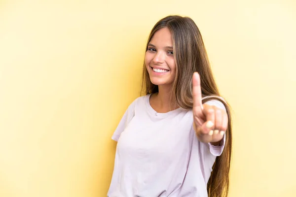 Молодая Белая Женщина Выделяется Жёлтом Фоне Показывая Поднимая Палец — стоковое фото