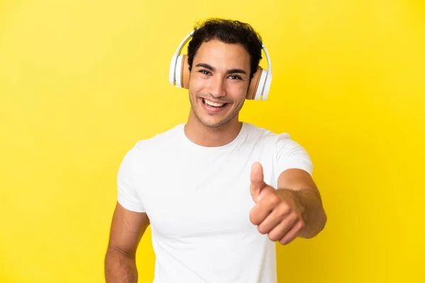 Kaukasische Knappe Man Geïsoleerde Gele Achtergrond Luisteren Muziek Met Duim — Stockfoto