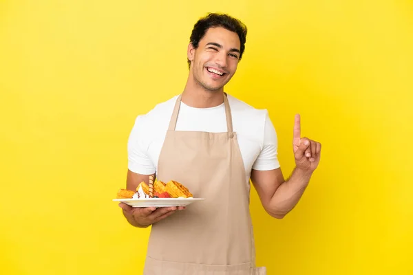 Restaurante Garçom Segurando Waffles Sobre Fundo Amarelo Isolado Mostrando Levantando — Fotografia de Stock