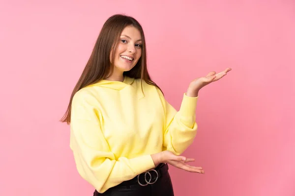 Tiener Kaukasisch Meisje Geïsoleerd Roze Achtergrond Uitstrekken Handen Naar Zijkant — Stockfoto
