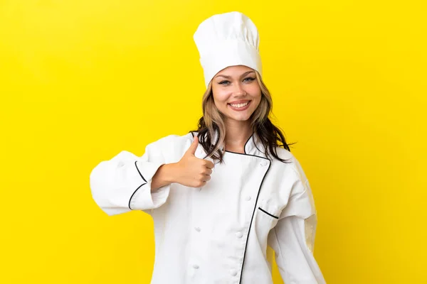 若いですロシア料理人女の子絶縁上の黄色の背景与えます親指アップジェスチャー — ストック写真