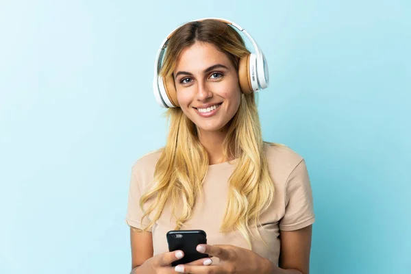 Jeune Uruguayenne Blonde Isolée Sur Fond Bleu Écoutant Musique Avec — Photo