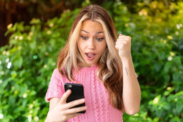 Junge Hübsche Frau Freien Mit Handy Und Siegesgeste — Stockfoto