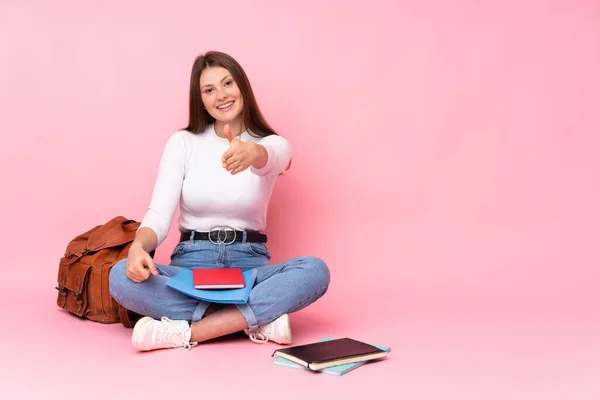 Adolescente Caucasiano Estudante Menina Sentado Chão Isolado Fundo Rosa Apertando — Fotografia de Stock