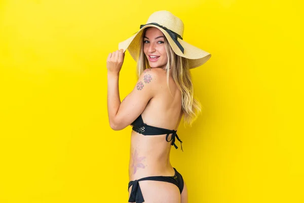 若いルーマニアの女性は夏休みに水着で黄色の背景に隔離 — ストック写真