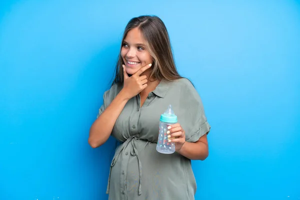 妊娠中の女性の青の背景に見て側と笑顔 — ストック写真