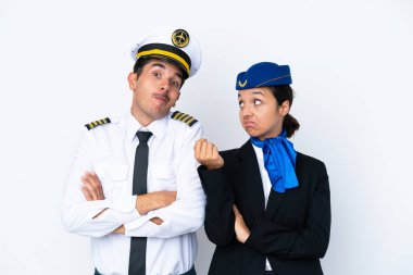 Uçak pilotu ve karışık yarış hostesi beyaz arka planda izole edilmiş. Omuzlarını kaldırırken şüphe uyandıran hareketler yapıyorlar.