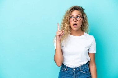 Kıvırcık saçlı kız mavi arka planda izole edilmiş.