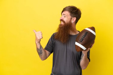 Kızıl saçlı beyaz adam sarı arka planda ragbi oynuyor. 