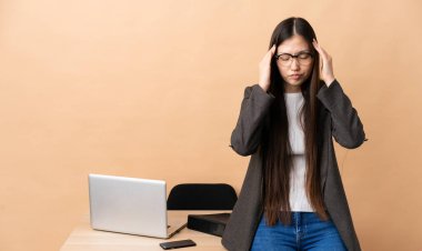 İş yerinde başı ağrıyan Çinli bir iş kadını.