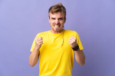 Mor arka planda izole edilmiş yakışıklı sarışın adam kötü bir durum yüzünden hayal kırıklığına uğradı.