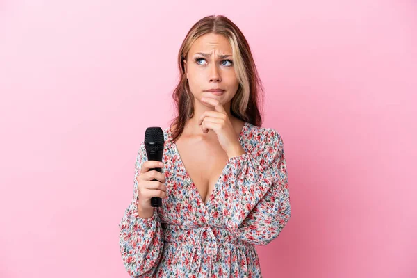 Young Russian Woman Holding Microphone Isolated Pink Background Having Doubts — Stock Photo, Image