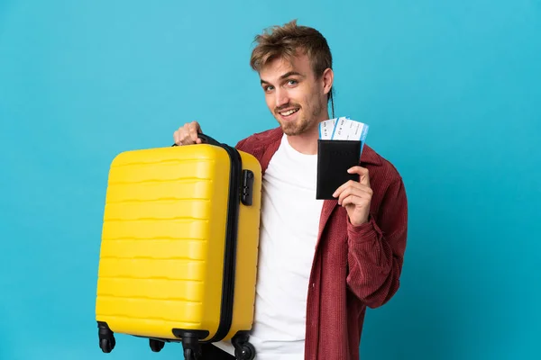 Jonge Knappe Blonde Man Geïsoleerd Blauwe Achtergrond Vakantie Met Koffer — Stockfoto