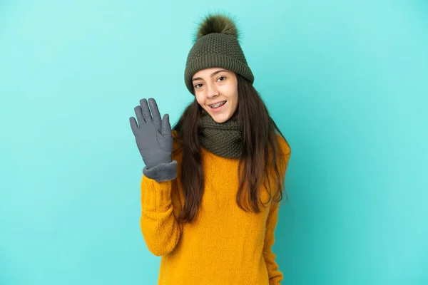 Νεαρή Γαλλίδα Κοπέλα Απομονωμένη Μπλε Φόντο Χειμερινό Καπέλο Χαιρετά Χέρι — Φωτογραφία Αρχείου