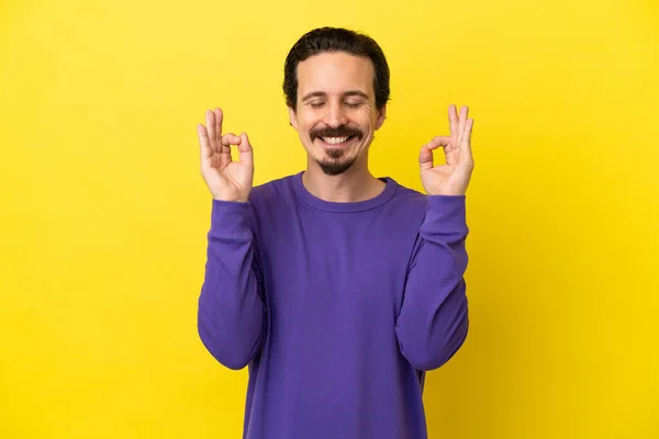 Joven Hombre Caucásico Aislado Sobre Fondo Amarillo Pose Zen — Foto de Stock