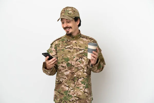 被隔离在白色背景下的士兵拿着咖啡和手机走了 — 图库照片