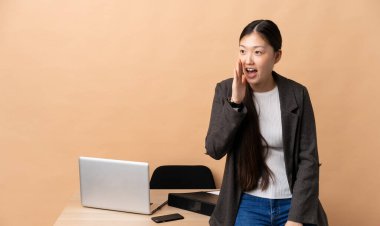 İş yerindeki Çinli iş kadını ağzı açık bağırıyor.