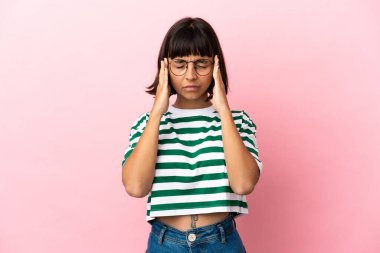 Pembe arka planda soyutlanmış, başı ağrıyan genç melez bir kadın.